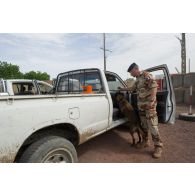 Un fusilier commando de l'Air fouille un véhicule avec son chien au poste de sécurité principal du camp Adji Kosseï à N'Djamena, au Tchad.