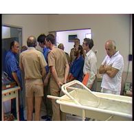 Visite d'une délégation scientifique étrangère à Moruroa. Contrôle aérien de l'aéroport. Hôpital du SMSR et chaîne de décontamination.