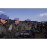 Le général Rob, chef du détachement kényan, tient un lance-roquette anti-char lors de sa visite guidée par le colonel Meille.