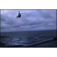 Arrivée d'un hélicoptère Super Puma pour un hélitreuillage sur un bâtiment de la Marine dans l'océan Pacifique.