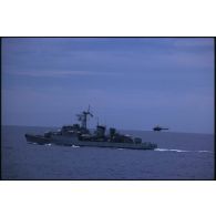 Aviso Enseigne de vaisseau Henry (F749) survolé par un hélicoptère Alouette III en pleine mer dans le Pacifique.