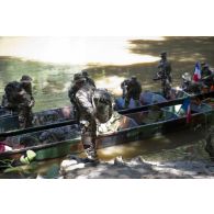 Des marsouins du 9e régiment d'infanterie de marine (9e RIMa) débarquent de leurs pirogues pour une patrouille dans la crique de Sparouine, en Guyane française.