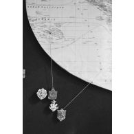 Insignes du régiment d’infanterie de marine du Pacifique - Polynésie (RIMAP-P), du 57e bataillon de commandement et de soutien du Pacifique (57e BCSP) et du bataillon du Pacifique, en lien avec une carte de Polynésie française, et insigne du 10e bataillon d'infanterie de marine (10e BIMa).<br>  .