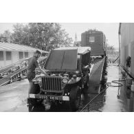 Une jeep Willys et une camionnette sur le plateau d'un camion de l'escadron de transport du 57e bataillon de commandement et de soutien du Pacifique (57e BCSP) au camp d'Arue.