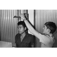 Examen médical des élèves gradés (PEG) du 57e bataillon de commandement et de soutien du Pacifique (57e BCSP) au camp d'Arue. Mesure de la taille sous la toise.