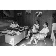 Le commissaire en chef Baric, chef de l'unité administrative du centre d'expérimentations du Pacifique (UA/CEP), avec les capitaines de frégate Benes et Le Brun, dans son bureau au camp d'Arue.