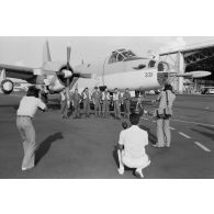 Photographie de groupe par la presse locale de l'équipage d'un avion Neptune de l'escadrille 12S de retour après la réussite d'une mission de sauvetage en mer.
