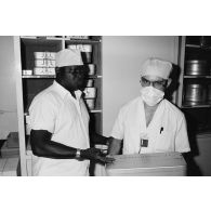 Personnel médical au bloc opératoire de l'hôpital militaire Jean Prince à Arue (Tahiti). Boîte de matériel gynécologique.