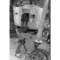 Le bureau postal militaire (BPM) de Moruroa et la boîte aux lettres. Bachi sur la selle du Solex.