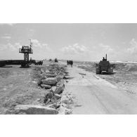 A Moruroa, chantier des légionnaires du 5e régiment mixte du Pacifique (5e RMP) sur une route. Un engin Caterpillar terrasse la zone.