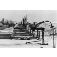 A Moruroa, édification d'un mur de protection contre les raz de marée par les légionnaires du 5e régiment mixte du Pacifique (5e RMP).