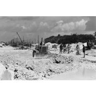 A Moruroa, édification d'un mur de protection contre les raz de marée par les légionnaires du 5e régiment mixte du Pacifique (5e RMP). Un engin Caterpillar terrasse la zone.