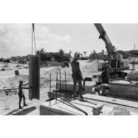A Moruroa, édification d'un mur de protection contre les raz de marée par les légionnaires du 5e régiment mixte du Pacifique (5e RMP). Mise en place de modules en béton.