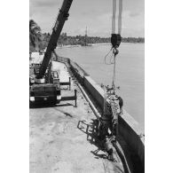 A Moruroa, édification d'un mur de protection contre les raz de marée par les légionnaires du 5e régiment mixte du Pacifique (5e RMP). Levage par une grue PPM.
