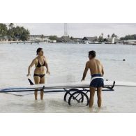 Baignade et planche à voile à Moruroa (Mururoa). Marie-Thérese Patrat, député du Rhône et secrétaire de la commission, et le colonel Bernard Gillis, commandant de la base interarmées (BIA).