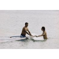 Baignade et planche à voile à Moruroa (Mururoa). Marie-Thérese Patrat, député du Rhône et secrétaire de la commission, et le colonel Bernard Gillis, commandant de la base interarmées (BIA).