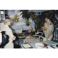 Louis Darinot, député de la Manche, président de la commission de la Défense nationale, signe le livre d'or sur le plateau du studio de télévision de Télé Muru à Moruroa (Mururoa) en présence du général de corps d’armée aérienne Michel Rouyer, directeur des centres d'expérimentations nucléaires (DIRCEN).