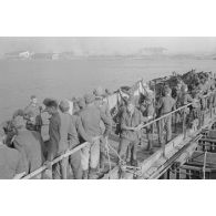 Fantassins et cavaliers attendent de traverser le fleuve, avec les chevaux préparés.