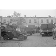Diverses véhicules militaires stationnent, en face de l’atelier de réparation, près de l’église de Petrovadosk (Carélie, Russie).