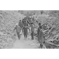 Un groupe d’hommes déblayent la rue.