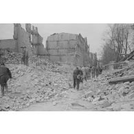 Des hommes déblayent la rue.