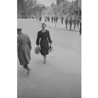 Dans la rue commerçante, une femme s’avance vers le photographe.
