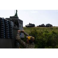 Un soldat belge alimente un véhicule blindé Piranha IIIC DF30 en obus de 30 mm sur le champ de tir de Cincu, en Roumanie.