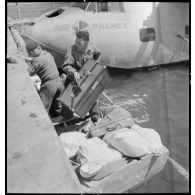 Après l'amerrissage, débarquement de sacs postaux et de bagages de l'hydravion de transport Lioré et Olivier H 246 Oranie, de la compagnie aérienne Air France.