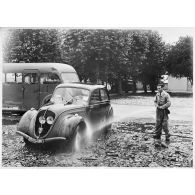 Nettoyage d'une Peugeot 202 du parc automobile stocké sur la base aérienne de Pau.