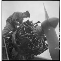 Un mécanicien assure la maintenance sur un des moteurs d'un avion de chasse Potez 63-11 sur la base aérienne de stockage de Pau.