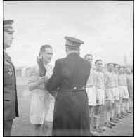 Le général de division aérienne Jean-Charles Romatet, chef d'état-major de l'armée de l'Air, remet un trophée à une équipe de rugby à l'issue d'un match pendant un championnat sur un stade à Clermont-Ferrand.