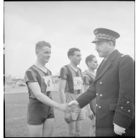 Le général de division aérienne Jean-Charles Romatet, chef d'état-major de l'armée de l'Air, félicite une équipe de rugby à l'issue d'un match pendant un championnat sur un stade à Clermont-Ferrand.