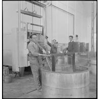 Un ouvrier de l'atelier de réparation de l'armée de l'Air (ARAA) de Limoges refroidit une pièce de moteur d'avion après un passage au four.