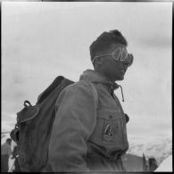 Portrait d'un volontaire de l'organisation Jeunesse et Montagne participant aux épreuves d'un concours de ski dans les Alpes.