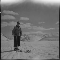 Un volontaire de l'organisation Jeunesse et Montagne participant aux épreuves d'un concours de ski dans les Alpes.