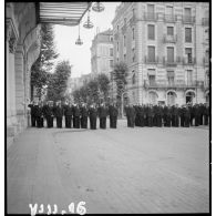 Lors de la cérémonie du 14 Juillet à Vichy, des cadres de l'armée de l'Air rendent les honneurs lors de la montée des couleurs sur la façade de l'hôtel Radio, siège du secrétariat d'Etat à l'Aviation.
