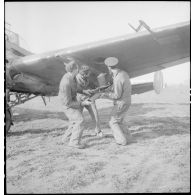 Mise en place de nacelles de mitrailleuses sous une aile d'un avion d'observation Potez 63-11 avant un départ en mission.