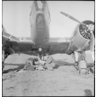 Mise en place d'une mitrailleuse sous le fuselage d'un avion d'observation Potez 63-11 avant un départ en mission.