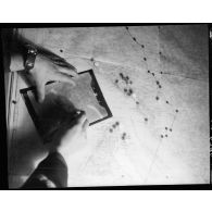 Exploitation des images d'une mission de reconnaissance photographique au-dessus de la Pointe de Grave et de Royan dans la salle de renseignement de l'escadrille III/33 Périgord.