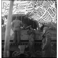 Dans le Haut-Rhin, des artilleurs du 62e régiment d'artillerie d'Afrique (62e RAA) approvisionnent le canon automoteur M7 Priest Dijon, camouflé par un filet.