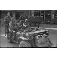 Fantassins de la 9e division d'infanterie coloniale (9e DIC) sur une jeep équipée d'une antenne fouet et d'une mitrailleuse Browning.