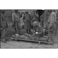 Un personnel médical de la 1re armée effectue un triage de soldats allemands blessés avant leur évacuation.