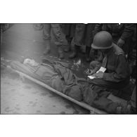 Un personnel médical de la 1re armée effectue un triage de soldats allemands blessés avant leur évacuation.