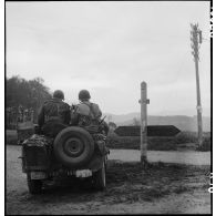 Jeep positionnée à un carrefour, un panneau de signalisation indiquant les directions de Emmendingen et Streitberg.