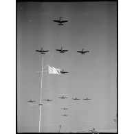 Des avions de chasse Bell P-63 Kingcobra de la 5e escadre de chasse volent en formation de croix de Lorraine au-dessus de Salon-de-Provence.