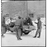 Pose de lignes téléphoniques dans un village du front dans la région de Sarreguemines (Moselle) par le génie américain. [description provisoire]