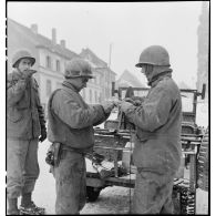 Pose de lignes téléphoniques dans un village du front dans la région de Sarreguemines (Moselle) par le génie américain. [description provisoire]