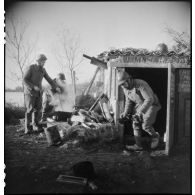 Préparation du café dans l'abri d'un groupe des Forces françaises de l'intérieur (FFI) dans les marais gelés d'un no man's land du secteur de Royan.