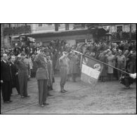 Le général de Gaulle salue le drapeau du 1er REC (régiment étranger de cavalerie) ? à Colmar. [description provisoire]