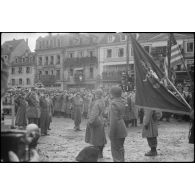 Le général de Gaulle salue les drapeaux français et américain à Colmar. [description provisoire]